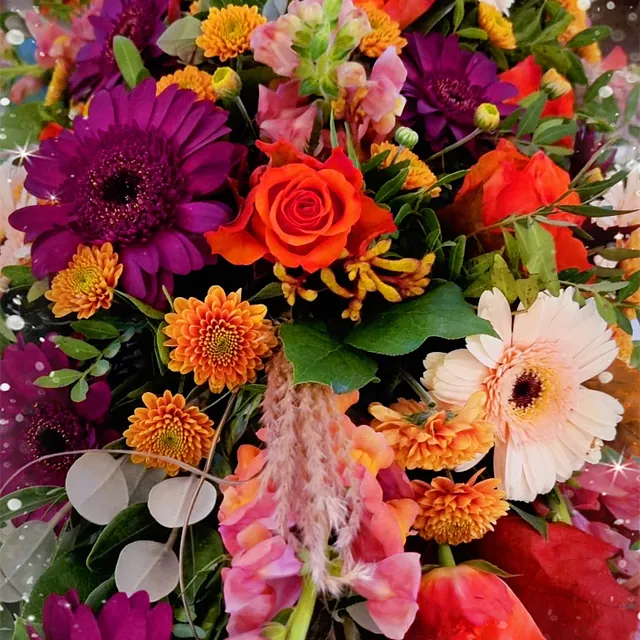 Fargerik blomsteroppsats med røde, lilla, oransje og hvite blomster, pyntet med stjerner.